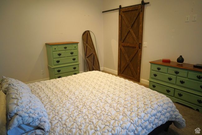 Carpeted bedroom featuring baseboards and a barn door | Image 24