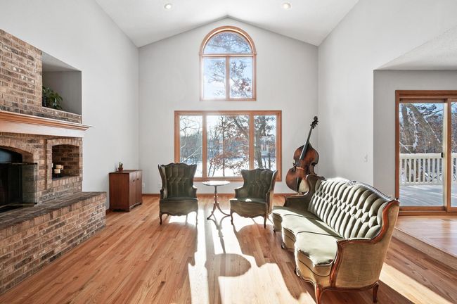 The great room offers a soaring vaulted ceiling, gorgeous hardwood flooring, a gas fireplace, and the most spectacular view of the lake! | Image 4