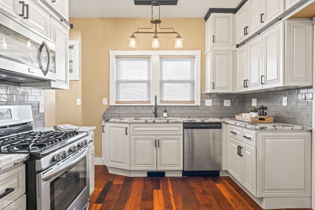 kitchen featuring appliances with stainless steel finishes, tasteful backsplash, and light stone countertops | Image 19
