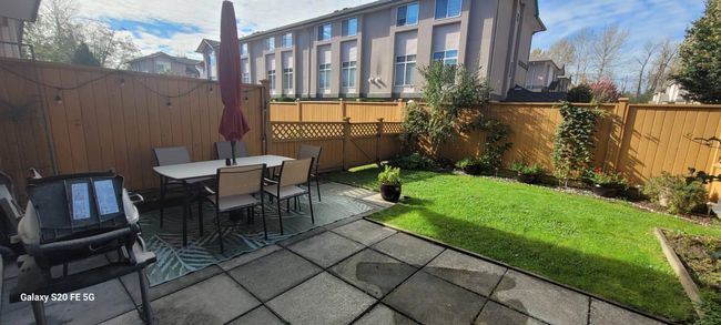 Exterior space featuring a fenced backyard, outdoor dining space, and a residential view | Image 26