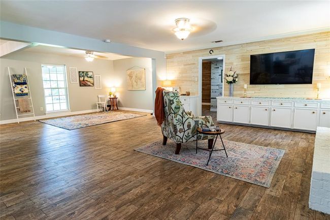 View from back door toward den with fireplace to the right, primary bedroom door and living area to the left. | Image 12