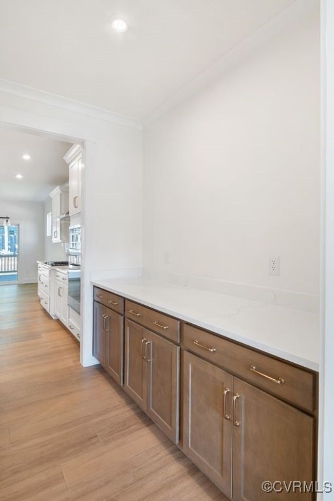 Photo represents the plan, not the actual home. Design selections may vary. A spacious kitchen with an island and pantry open to an adjoining dining area and the family room. | Image 11