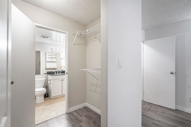 Bathroom with toilet, vanity, wood finished floors, and a textured ceiling | Image 18