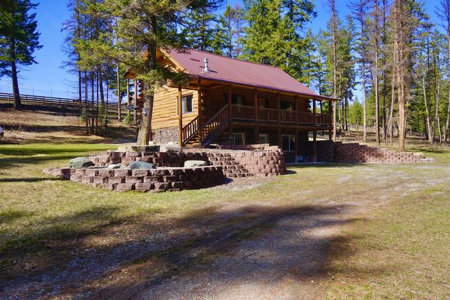 Rear view of property with metal roof, a yard, stairway, and log exterior | Image 13