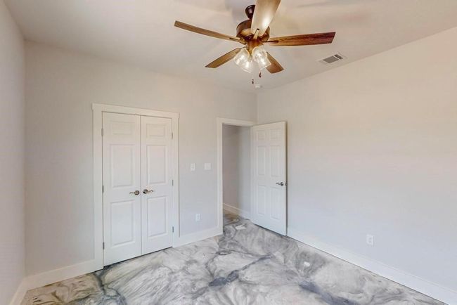 Unfurnished bedroom with a closet, baseboards, a ceiling fan, and visible vents | Image 26