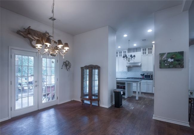 Dining room featuring a chandelier, dark wood-type flooring, french doors, and recessed lighting | Image 9