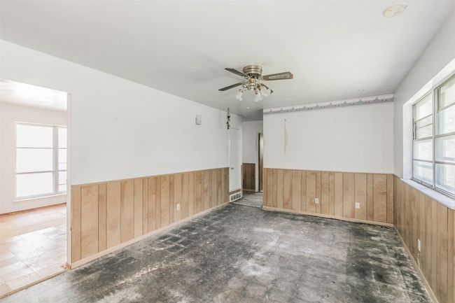 Empty room featuring wood walls, wainscoting, and ceiling fan | Image 19