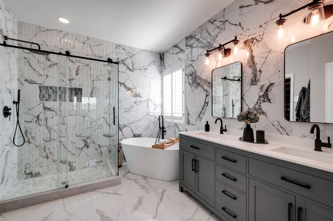 The primary ensuite bath is simply spa worthy with the most stunning tile selection, a freestanding tub, a walk-in shower with frameless glass surround/door and a double vanity. Please notice that the entire walls are tiled. | Image 27