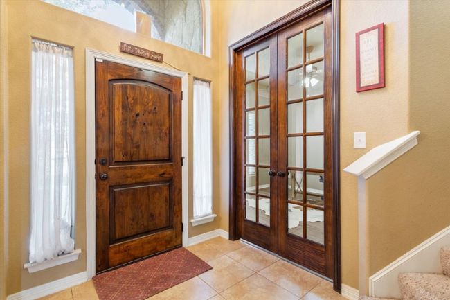 Entrance foyer featuring stairs, light tile patterned floors, french doors, and baseboards | Image 7