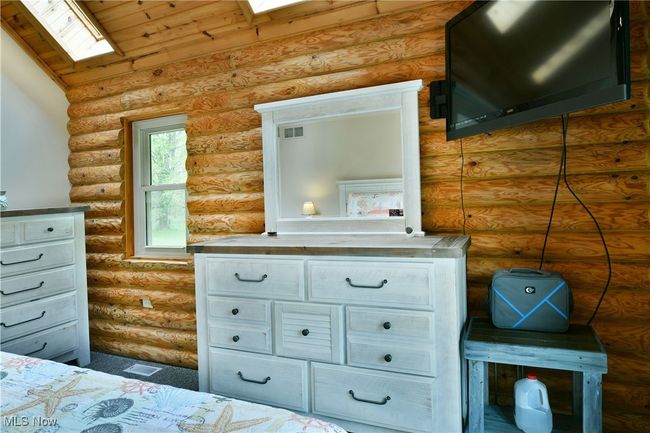 Bedroom featuring a skylight and rustic walls | Image 28