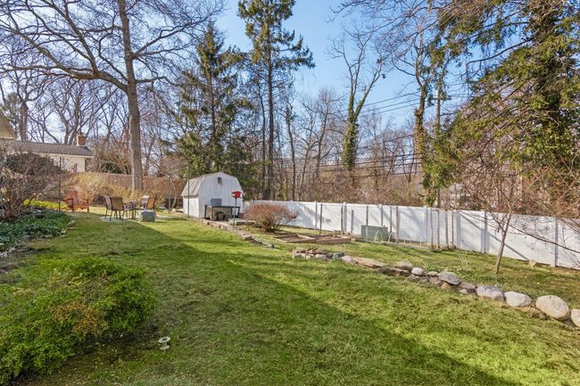View of landscaped yard fully fenced with gardening and planting areas | Image 22