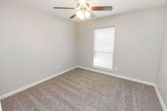 Carpeted spare room featuring a ceiling fan and baseboards | Image 32