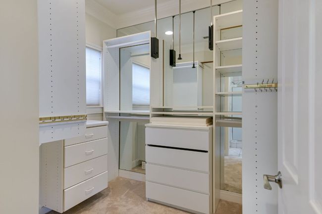 Second spacious primary closet with custom built-ins and natural light. | Image 23