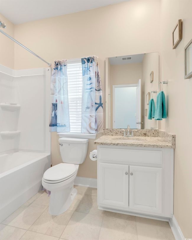 Full bathroom with vanity, tile patterned floors, washtub / shower combination, and toilet | Image 27