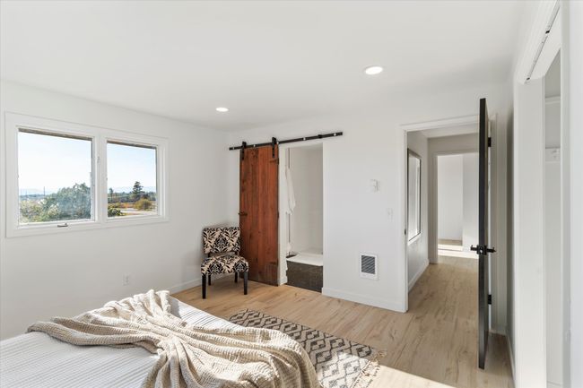 Bedroom with a barn door and light hardwood / wood-style floors | Image 25