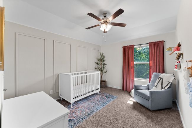 Bedroom featuring heating unit, carpet, a crib, and a ceiling fan | Image 20