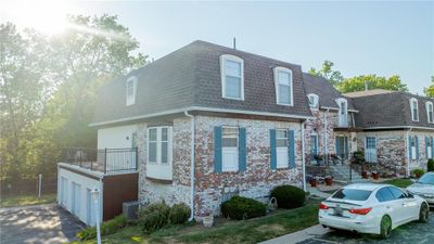 View of front facade featuring a balcony, central AC unit, and a garage | Image 1