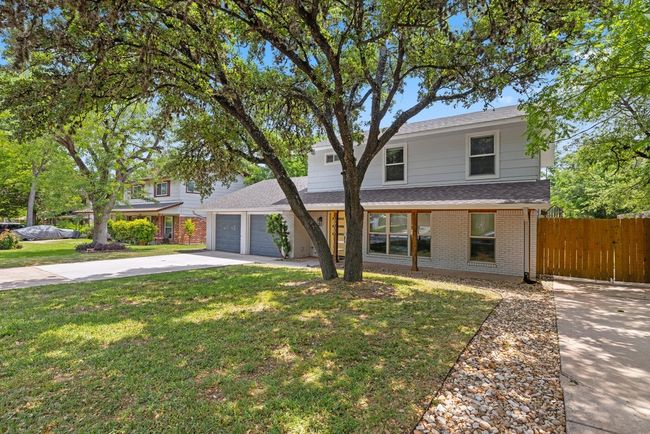 Traditional-style home featuring fence, concrete driveway, an attached garage, brick siding, and a front yard | Image 6