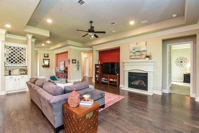 The cast stone mantle surrounding the fireplace is a rich focal point! An inset niche next to it allows space for a television or shelves. | Image 16