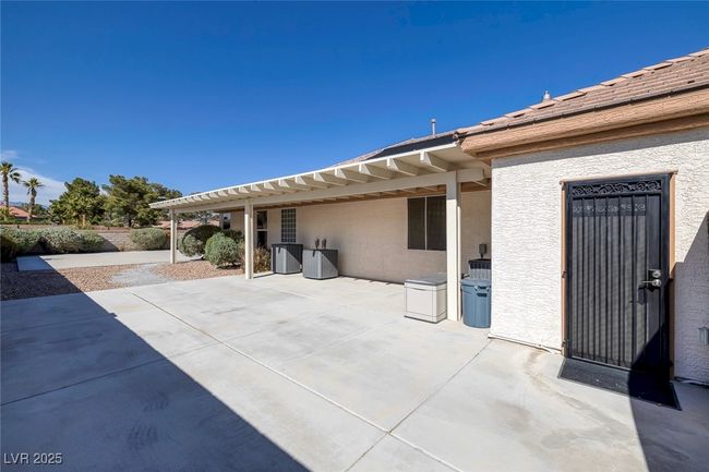 Covered Pato Area on West side for shade & to protect A/C Units Door into Garage | Image 64