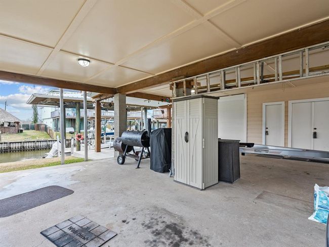 Area under house has garage for golf cart, 3rd full bath for cleaning up before entering the house and storage closets. | Image 24
