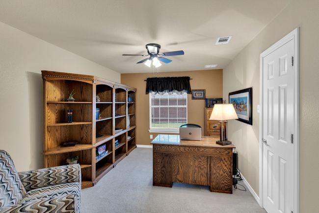 3rd bedroom on 1st floor with closet and fan currently being used as an office. | Image 25