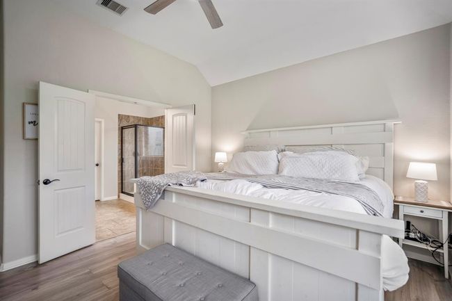 From the cozy bay window nook, glance back through the elegant double doors to the bright primary bathroom — a seamless flow that creates a calm, connected retreat just steps away. | Image 19