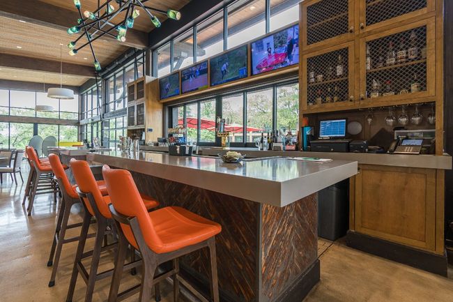 Indoor dry bar featuring finished concrete flooring, a towering ceiling, wooden ceiling, and pendant lighting | Image 30
