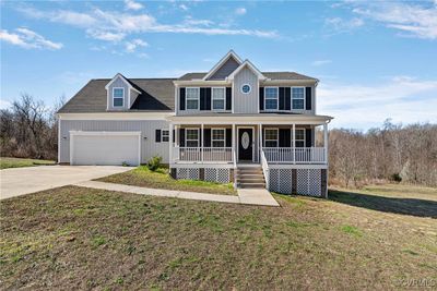 View of front of house featuring a porch, a garage, and a front lawn | Image 1