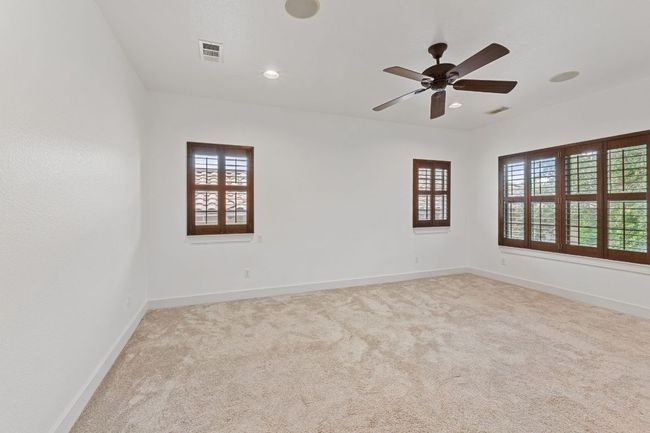 Empty room with carpet flooring, ceiling fan, and recessed lighting | Image 28