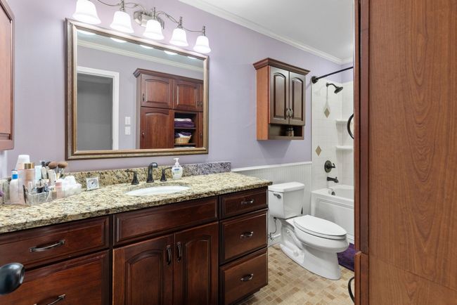 Bathroom with crown molding, vanity, a wainscoted wall, and shower / bathtub combination | Image 14