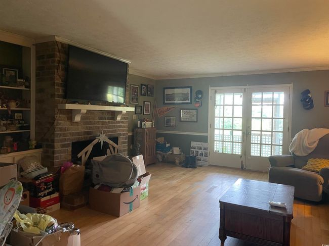 Living area with hardwood / wood-style floors, ornamental molding, and a fireplace | Image 7