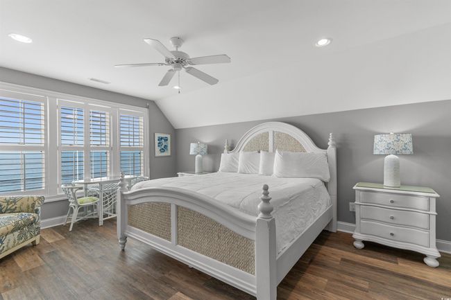 Primary Oceanfront Bedroom featuring vaulted ceiling, wood finished floors, recessed lighting, and ceiling fan | Image 24