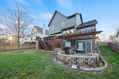 Rear view of house with a pergola, a wooden deck, and a lawn | Image 3