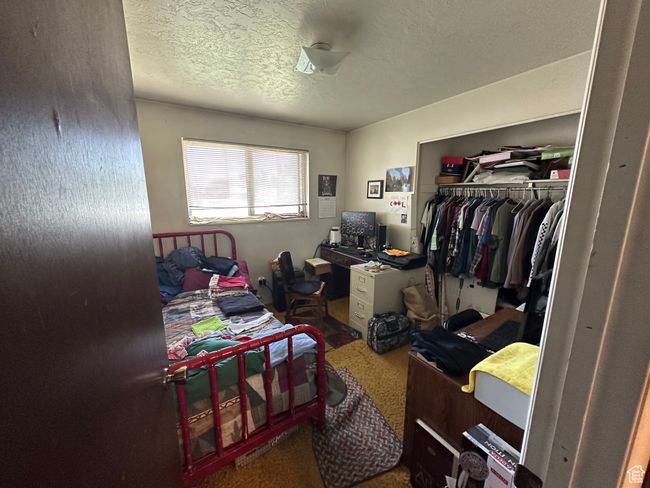Carpeted bedroom with a closet and a textured ceiling | Image 12
