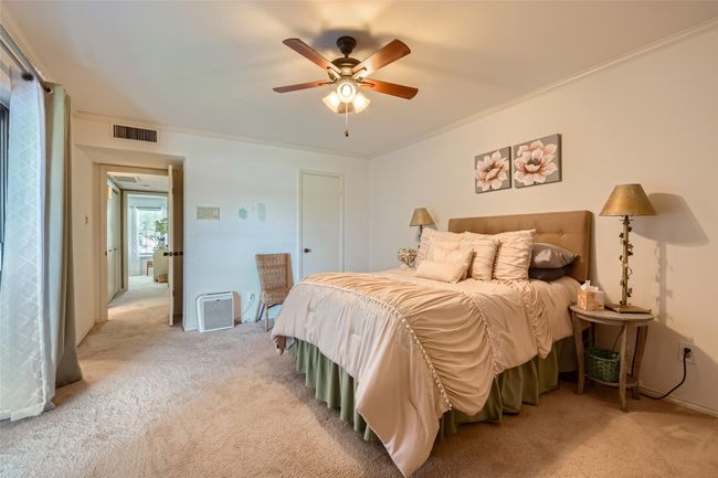 Bedroom featuring light colored carpet, crown molding, and ceiling fan | Image 15