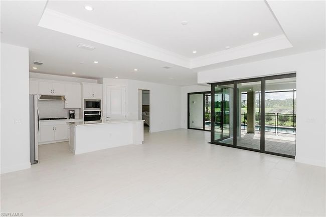 Unfurnished living room with a tray ceiling, crown molding, and recessed lighting | Image 14
