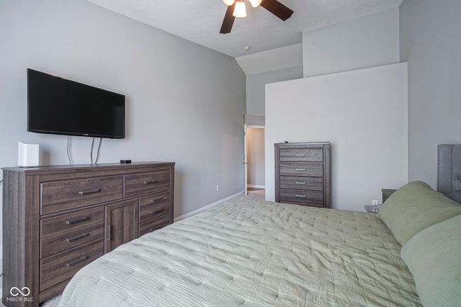 bedroom with baseboards, ceiling fan, carpet flooring, and vaulted ceiling | Image 20