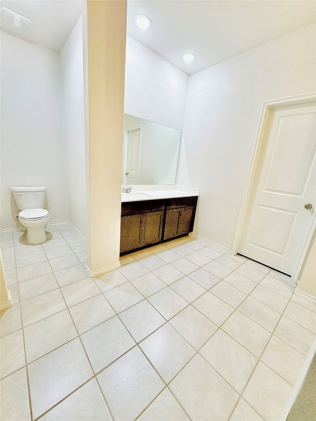 Bathroom featuring vanity, toilet, tile patterned flooring, baseboards, and recessed lighting | Image 23
