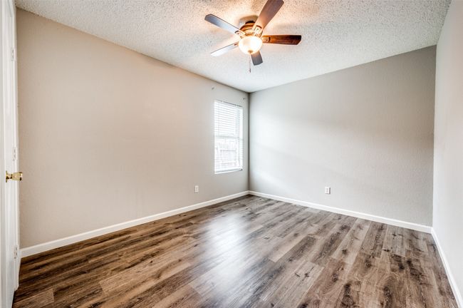 Spare room featuring ceiling fan, a textured ceiling, wood finished floors, and baseboards | Image 16