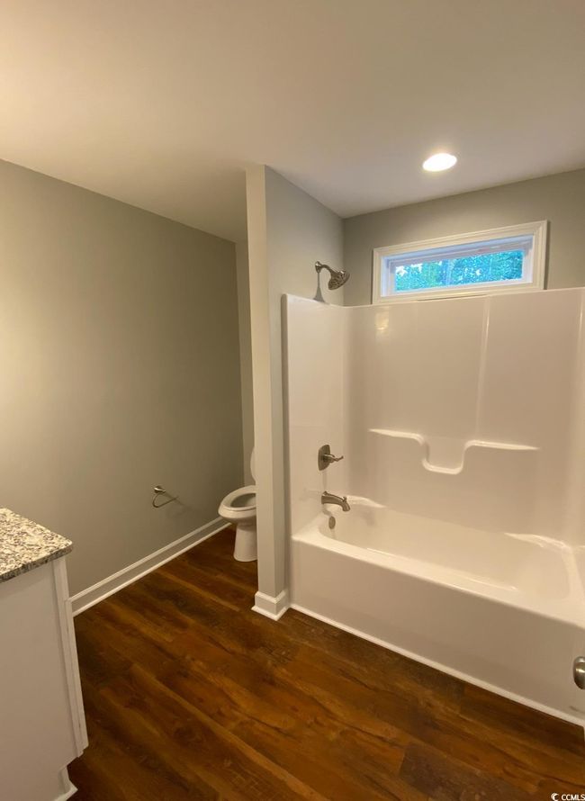 Bathroom with toilet, shower combination, vanity, wood finished floors, and baseboards | Image 9