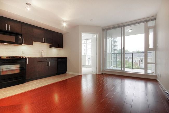 Kitchen with decorative backsplash, baseboards, wood finished floors, and black appliances | Image 7