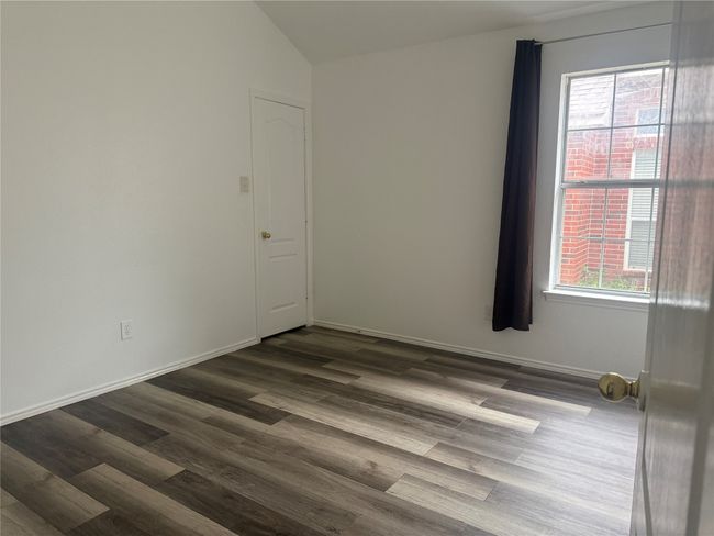 Unfurnished room featuring vaulted ceiling, baseboards, and dark wood-type flooring | Image 16
