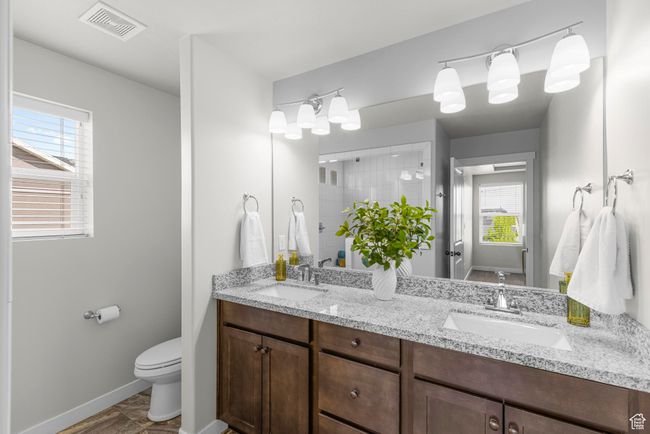 Full bathroom with toilet, a sink, tiled shower, and visible vents | Image 21