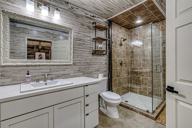 Bathroom featuring a shower stall, vanity, and concrete flooring for easy upkeep | Image 38