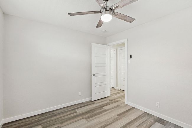 Spare room featuring ceiling fan, light wood finished floors, and baseboards | Image 32
