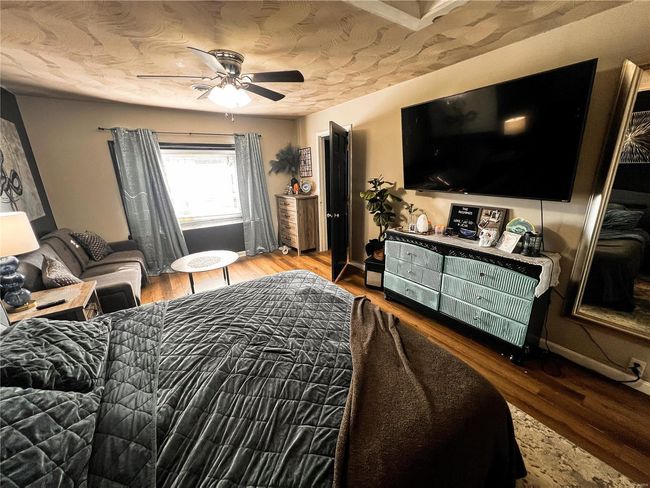 Bedroom with ceiling fan, wood finished floors, and baseboards | Image 22