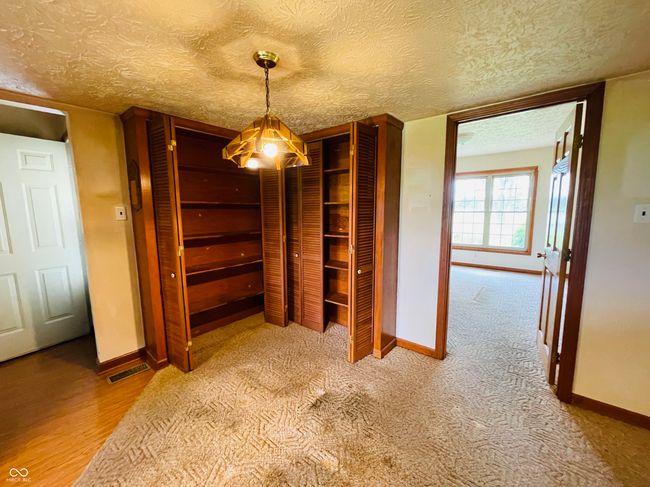 unfurnished dining area featuring baseboards, a textured ceiling, and carpet flooring | Image 20