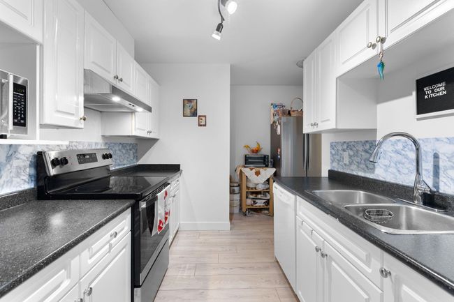 Kitchen featuring appliances with stainless steel finishes, under cabinet range hood, and dark countertops | Image 10