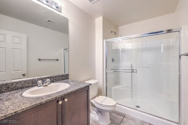 Full bath featuring toilet, a stall shower, tile patterned flooring, and visible vents | Image 28